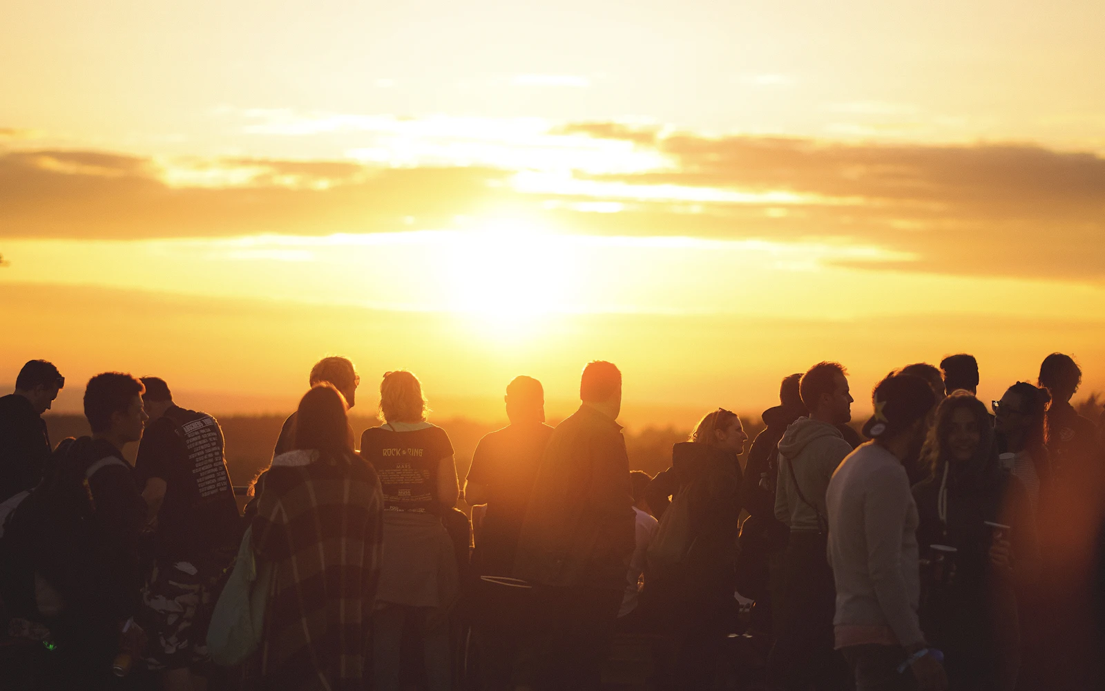 Grupo de gente al atardecer junto al mar